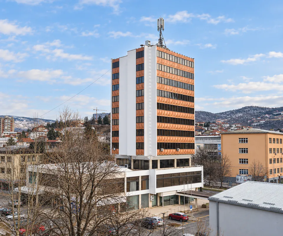 Hotel Oaza tower rising above central Štip, with red-roofed houses climbing the hills behind